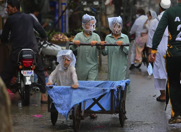 Các thiếu niên đội túi trên đầu trong trận mưa ở Peshawar, Pakistan Các thiếu niên đội túi trên đầu trong trận mưa ở Peshawar, Pakistan - Sputnik Việt Nam