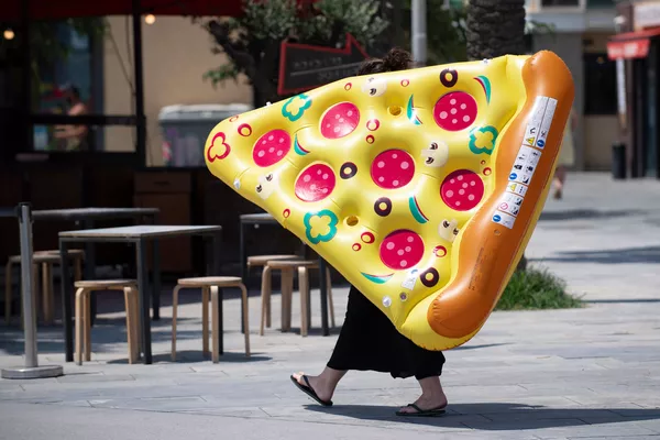 Người phụ nữ mang chiếc nệm bơm hơi hình bánh pizza Người phụ nữ mang chiếc nệm bơm hơi hình bánh pizza - Sputnik Việt Nam
