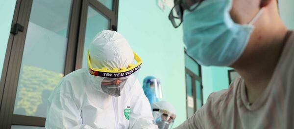 Nhân viên y tế lấy mẫu máu để xét nghiệm nhanh cho người dân tại Trạm Y tế phường Dịch Vọng, quận Cầu Giấy. - Sputnik Việt Nam