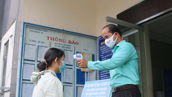 Hội Chữ thập đỏ và Đoàn thanh niên Phường 10, Quận 3 thực hiện đo thân nhiệt và hướng dẫn người dân rửa tay phòng chống dịch COVID – 19 trước khi vào trụ sở UBND. - Sputnik Việt Nam