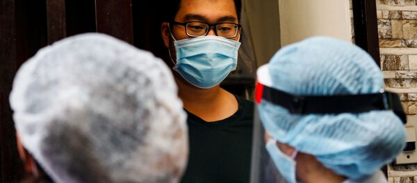 Nhân viên y tế trao đổi với người dân địa phương cạnh nhà của một bệnh nhân nhiễm coronavirus ở Hà Nội, Việt Nam. - Sputnik Việt Nam