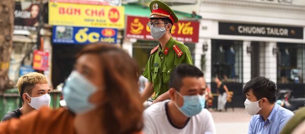 Một cảnh sát đeo mặt nạ tại một trung tâm xét nghiệm coronavirus tại Hà Nội - Sputnik Việt Nam