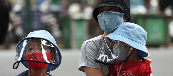 Mẹ và con xếp hàng chờ xét nghiệm coronavirus tại một trung tâm test nhanh ở Hà Nội, Việt Nam. - Sputnik Việt Nam