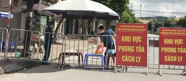 Người dân trong khu vực phong tỏa trên phố Ngô Quyền (Hải Dương) nhận thực phẩm tiếp tế tại hàng rào cách ly ngày 16/8 - Sputnik Việt Nam