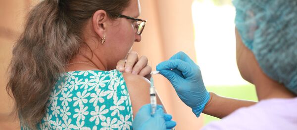 Một nhân viên y tế tiêm phòng cho một phụ nữ. - Sputnik Việt Nam