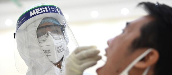 Nhân viên y tế của quận Cầu Giấy, Hà Nội tiến hành lấy mẫu dịch hầu họng để xét nghiệm bằng phương pháp RT-PCR của người dân từ Đà Nẵng trở về. - Sputnik Việt Nam