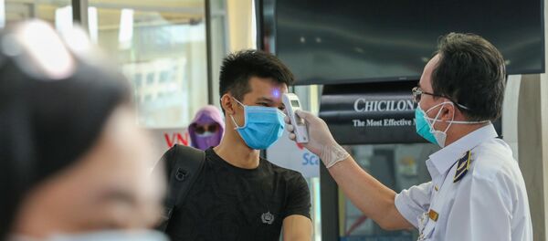 Các hành khách được kiểm tra thân nhiệt trước khi vào làm thủ tục tại sân bay Quốc tế Đà Nẵng.  - Sputnik Việt Nam