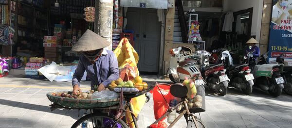 Người bán hàng dưới trời nắng nóng trên đường Tràng Thi. - Sputnik Việt Nam