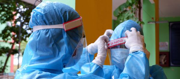 Đôi bạn thân 16 tuổi Phạm Đặng Gia Huy và Hồ Ngọc Oanh hỗ trợ nhau bảo hộ an toàn trước khi làm nhiệm vụ trong khu cách ly. - Sputnik Việt Nam