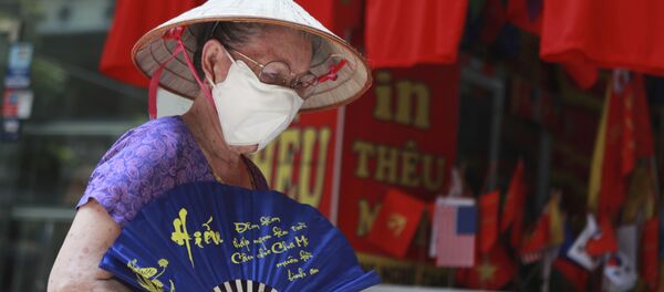 Một người phụ nữ đeo khẩu trang trên đường phố ở Hà Nội, Việt Nam. - Sputnik Việt Nam
