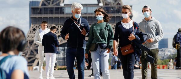 Người qua đường đeo khẩu trang y tế bảo vệ tại Tháp Eiffel ở Paris, Pháp Người qua đường đeo khẩu trang y tế bảo vệ tại Tháp Eiffel ở Paris, Pháp - Sputnik Việt Nam