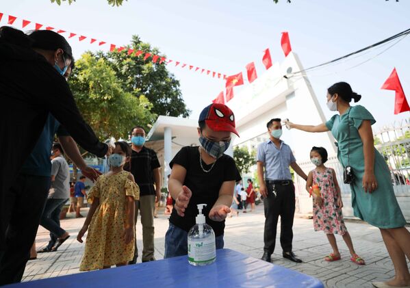 Trường Tiểu học Thịnh Liệt, quận Hoàng Mai (Hà Nội) thực hiện đo thân nhiệt, sát khuẩn tay cho phụ huynh và học sinh khối lớp 1 ngay từ ngày đầu tới trường - Sputnik Việt Nam