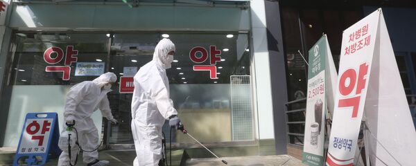 Nhân viên khử trùng trước một hiệu thuốc ở Hàn Quốc - Sputnik Việt Nam