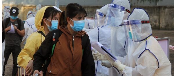 Nhân viên Y tế hướng dẫn các công dân thực hiện các thủ tục khi vào khu cách ly tập trung - Sputnik Việt Nam