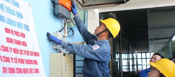 Công nhân EVN HCMC lắp đặt bộ hòa lưới (Inverter) điện của pin năng lượng mặt trời với điện lưới điện quốc gia - Sputnik Việt Nam