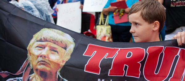 Một cậu bé trên phố khi đi qua đoàn xe với Tổng thống Mỹ Donald Trump. Kenosha. Hoa Kỳ - Sputnik Việt Nam