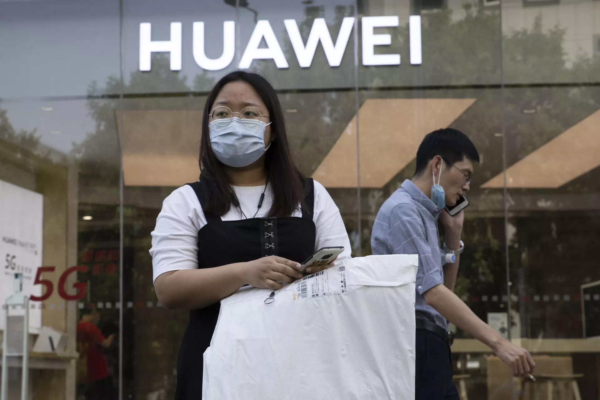 Cô gái đeo khẩu trang y tế trên nền của cửa hàng Huawei. Bắc Kinh - Sputnik Việt Nam, 1920, 06.04.2022