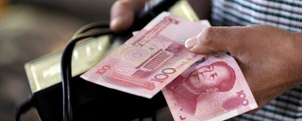 Một người đàn ông cầm nhân dân tệ - Sputnik Việt Nam