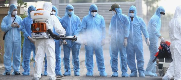 Chuyên gia chăm sóc sức khỏe khử trùng cho bệnh nhân Việt Nam đến bằng COVID-19. - Sputnik Việt Nam