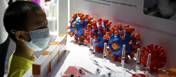Một cậu bé nhìn vào việc lắp đặt vắc-xin và tế bào coronavirus tại triển lãm CIFTIS ở Bắc Kinh - Sputnik Việt Nam