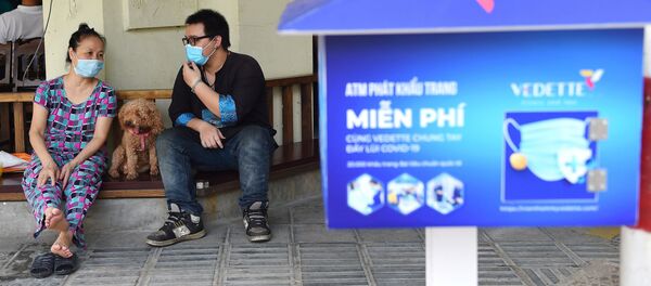 Những người ngồi trong quán cà phê cạnh máy bán khẩu trang miễn phí ở Hà Nội. - Sputnik Việt Nam