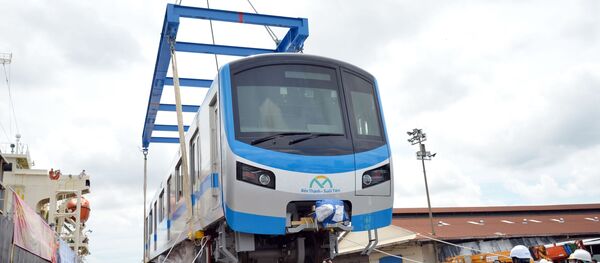  Các chuyên gia, kỹ sư đưa toa xe đầu tiên của đoàn tàu xuống xe siêu trường, siêu trọng.  - Sputnik Việt Nam