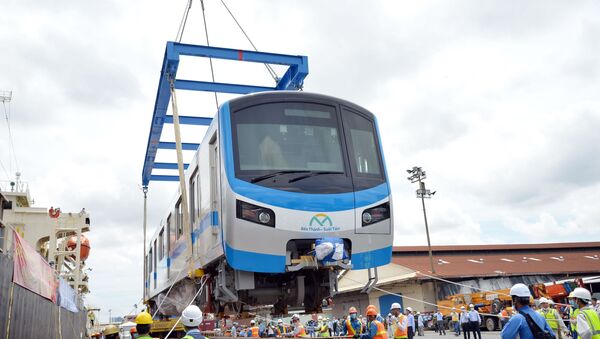  Các chuyên gia, kỹ sư đưa toa xe đầu tiên của đoàn tàu xuống xe siêu trường, siêu trọng.  - Sputnik Việt Nam