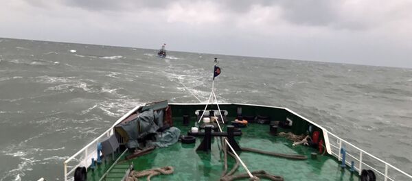 Tàu CSB 8003 lai kéo tàu cá NA 93248 TS về cảng Cửa Lò. - Sputnik Việt Nam