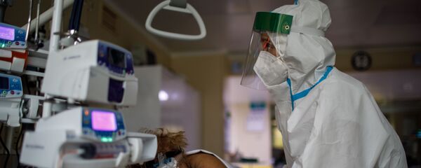 Một bác sĩ điều trị một bệnh nhân COVID-19. Một bác sĩ điều trị một bệnh nhân COVID-19. - Sputnik Việt Nam