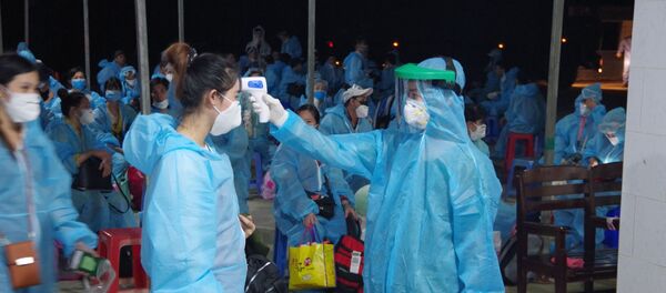 Đo thân nhiệt cho công dân trước khi tiếp nhận. - Sputnik Việt Nam