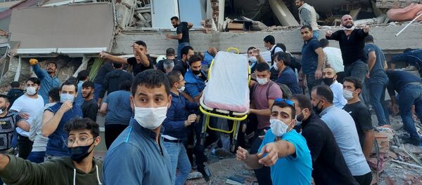 Lực lượng cứu hộ và cư dân địa phương sơ tán nạn nhân vụ sập nhà do hậu quả động đất ở tỉnh Izmir, Thổ Nhĩ Kỳ. - Sputnik Việt Nam