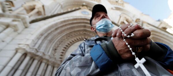 Một người đàn ông lần hạt tại Nhà thờ Đức Bà ở Nice, nơi xảy ra vụ tấn công - Sputnik Việt Nam