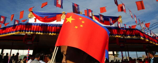 Người phụ nữ Campuchia với lá cờ Trung Quốc đi qua cầu Hữu nghị Campuchia-Trung Quốc trong lễ khai trương cầu này ở Tahmao - Sputnik Việt Nam