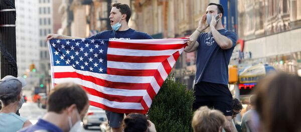A man holds U.S. flag as people celebrate media announcing that Democratic U.S. presidential nominee Joe Biden has won the 2020 U.S. presidential election on Union Square in the Manhattan borough of New York City, U.S. - Sputnik Việt Nam