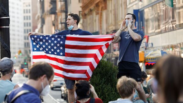 A man holds U.S. flag as people celebrate media announcing that Democratic U.S. presidential nominee Joe Biden has won the 2020 U.S. presidential election on Union Square in the Manhattan borough of New York City, U.S. - Sputnik Việt Nam