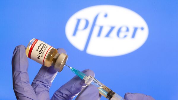 Lọ vắc xin chống сoronavirus trên nền logo của công ty dược phẩm Pfizer. - Sputnik Việt Nam