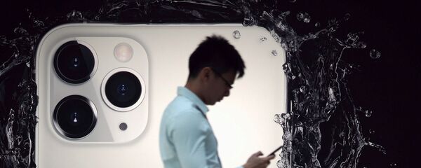 Người đàn ông trên nền quảng cáo iPhone 11 Pro - Sputnik Việt Nam