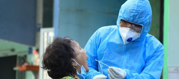 Nhân viên y tế lấy mẫu xét nghiệm người dân trong khu vực Lô E, Lò Gốm (Phường 7, Quận 6). Ảnh: Đinh Hằng - TTXVN - Sputnik Việt Nam