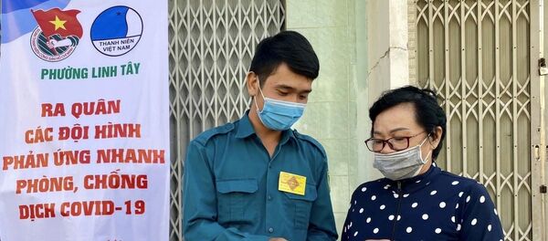 Chiến sĩ dân quân phường Linh Tây (Quận Thủ Đức) phát khẩu trang, dung dịch rửa tay miễn phí cho người dân. - Sputnik Việt Nam