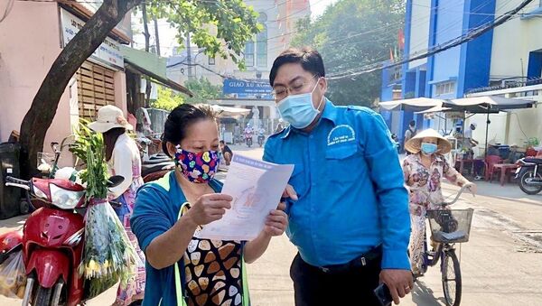 Anh Ngô Minh Hải, Phó Bí thư Thành Đoàn, Chủ tịch Hội Liên hiệp Thanh niên Việt Nam Thành phố Hồ Chí Minh trực tiếp tham gia cùng các chiến sĩ đoàn viên thanh niên tình nguyện tuyên truyền, vận động người dân thực hiện phòng dịch tại khu vực Quận 4. - Sputnik Việt Nam