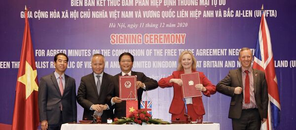 Bộ trưởng Công Thương Trần Tuấn Anh và bà Liz Truss, Bộ trưởng Thương mại Quốc tế Vương quốc Liên hiệp Anh và Bắc Ireland ký kết biên bản. - Sputnik Việt Nam
