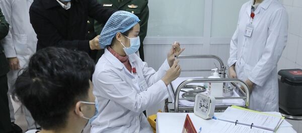 Bác sĩ chuẩn bị tiêm mũi vaccine Nanocovax ngừa COVID-19 đầu tiên cho tình nguyện viên. Đây là vaccine đầu tiên của Việt Nam được đưa vào thử nghiệm lâm sàng. - Sputnik Việt Nam