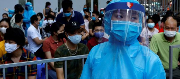 Nhân viên y tế mặc đồ bảo hộ và người xếp hàng tại Trung tâm xét nghiệm coronavirus ở Hà Nội. - Sputnik Việt Nam