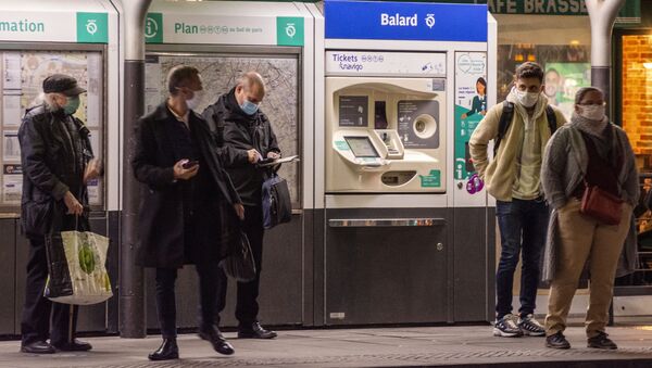 Hành khách đeo khẩu trang bảo vệ tại một bến xe công cộng ở Paris. - Sputnik Việt Nam