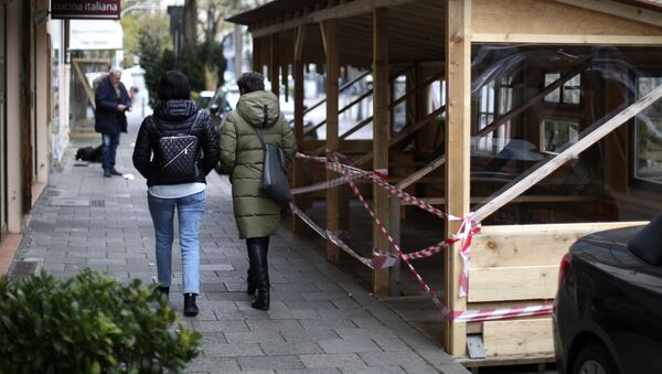 Mọi người đi ngang qua một nhà hàng đã đóng cửa trong đợt phong tỏa ở Munich. - Sputnik Việt Nam