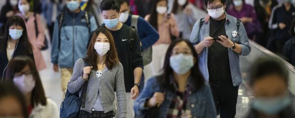 Cư dân vùng ngoại ô đeo khẩu trang ở điểm trung chuyển tàu điện ngầm ở Hồng Kông. - Sputnik Việt Nam