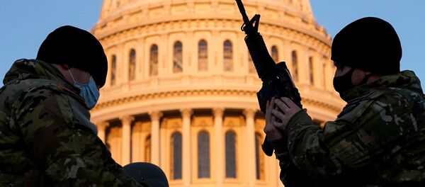 Một thành viên của Lực lượng Vệ binh Quốc gia Hoa Kỳ nhận vũ khí bên ngoài tòa nhà Capitol ở Washington DC - Sputnik Việt Nam