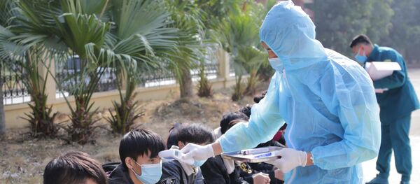 Kiểm tra y tế các trường hợp vượt biên trái phép chuẩn bị được đưa đi cách ly nhằm đảm bảo không có sự lây lan dịch bệnh tại khu cách ly cửa khẩu Ma Lù Thàng. - Sputnik Việt Nam