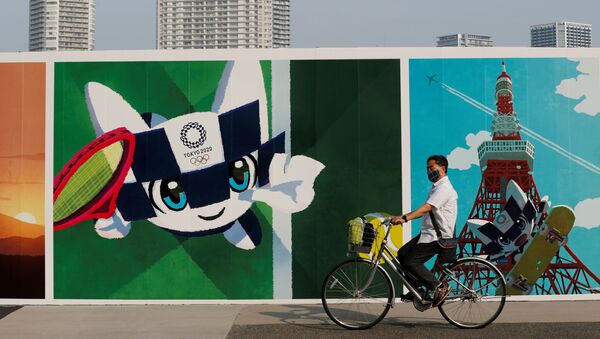 Một người đàn ông đi xe đạp lướt qua bức vẽ graffiti về chủ đề Thế vận hội Olympic ở Nhật Bản - Sputnik Việt Nam