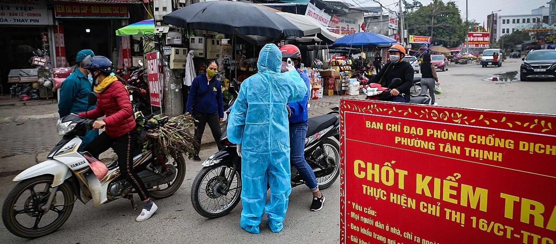 Lực lượng chức năng lập chốt thực hiện nghiêm việc đo thân nhiệt, nhắc nhở người dân tuân thủ đeo khẩu trang tại các điểm chợ.  - Sputnik Việt Nam, 1920, 01.02.2021